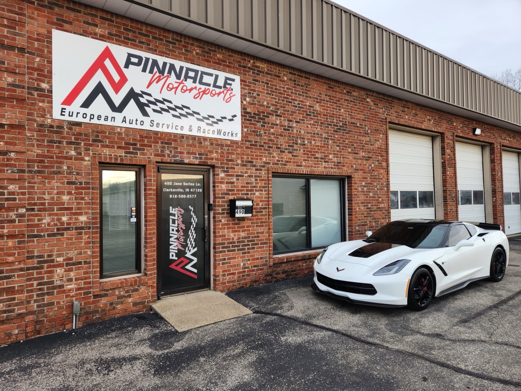 Pinnacle Motorsports shop exterior with Corvette in front of brick storefront
